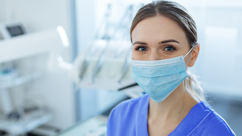 Behandlare med munskydd tittar tryggt in i kameran