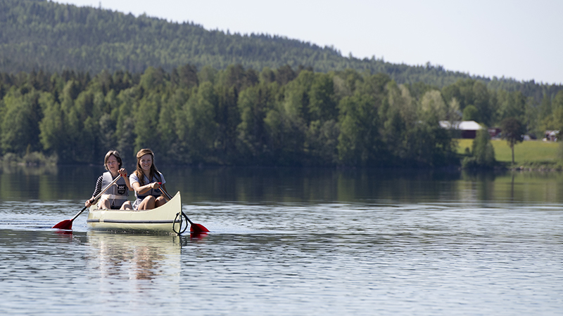 Kanot på en sjö med skog bakom.
