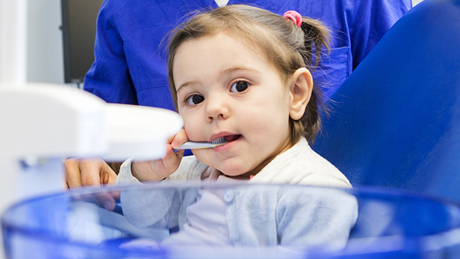 litet barn med tandborste i munnen