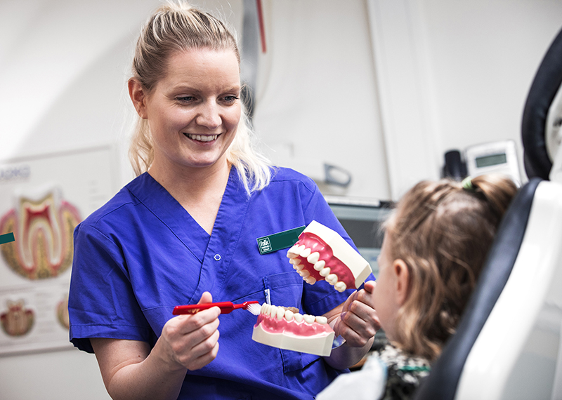 tandhygienist demonstrerar för patient