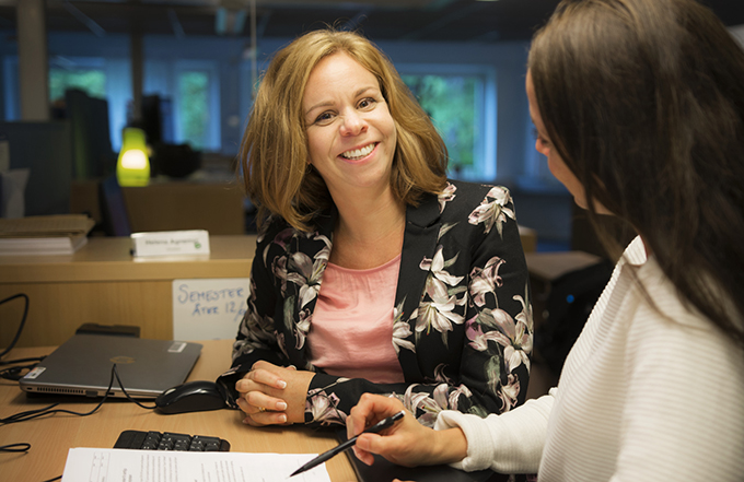Medarbetare samtalar stående vid ett skrivbord.