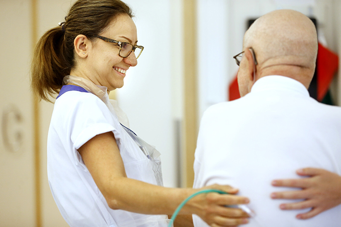 Vårdpersonal har ögonkontakt och stöttar patient.