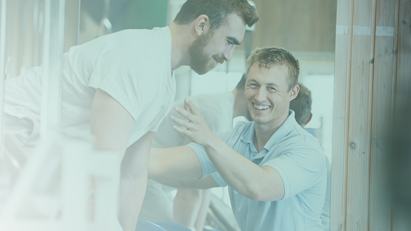 Fysioterapeut stöttar en patient.