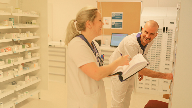 En kvinna och man i ett läkemedelsförråd.