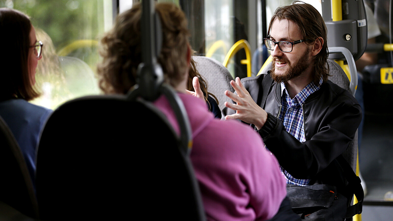 Tre passagerare inuti en buss.