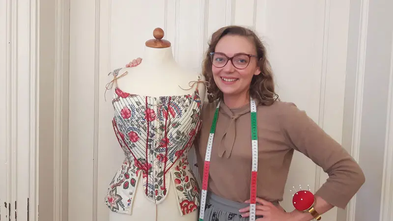 Kvinna i glasögon bredvid provdocka.