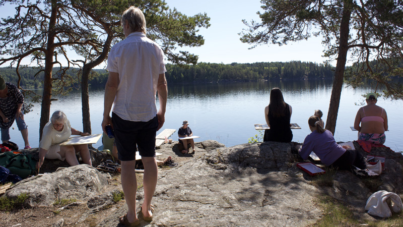 En person bär på en stor hög färgglada tyger