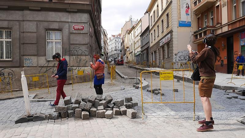 Bild på människor med hörlurar i stadsmiljö.