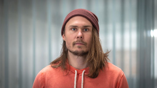 Ung man med mössa och långt hår.