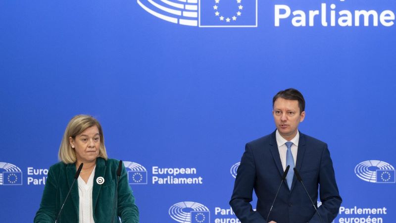 Två personer står framför två mikrofoner.