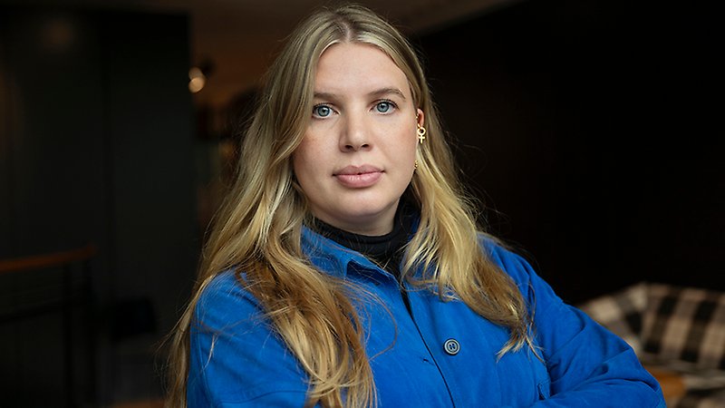 Kvinna med långt hår tittar rakt fram.